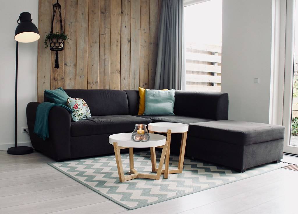 light candle on round white coffee table and sectional sofa - Credit to https://myfriendscoffee.com/